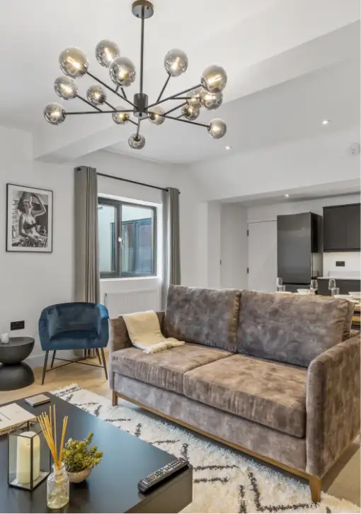 living room with velvet sofa and modern chandelier.